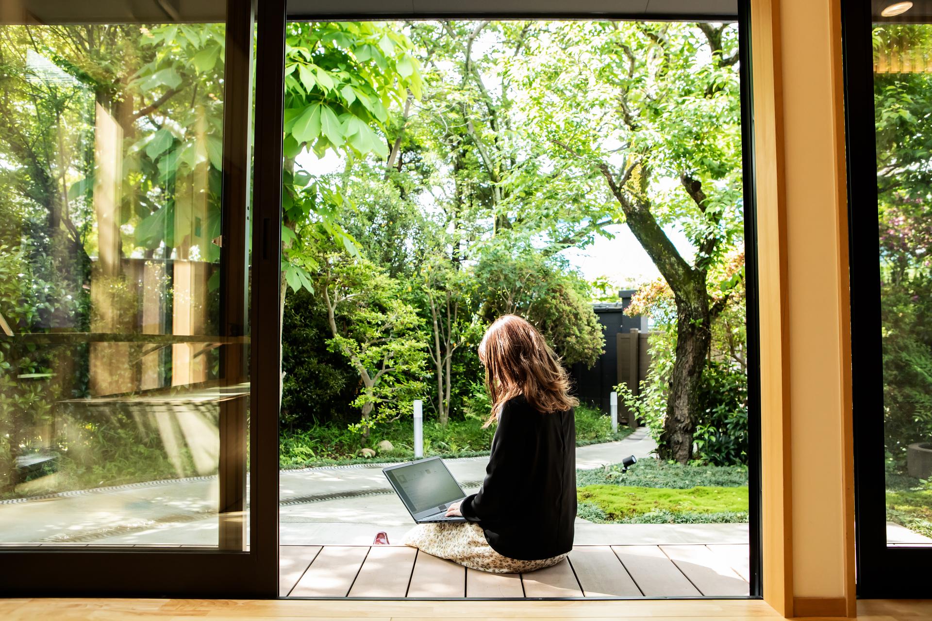 a person sitting on a rug using a laptop